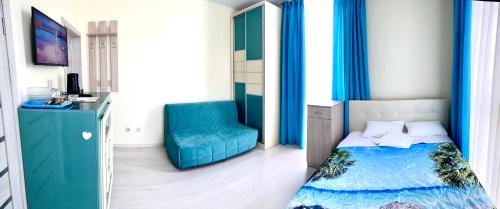 カバルジンカにあるMore Udachi Gostevoy Dvorのベッドルーム(青いベッド1台、青い椅子付)