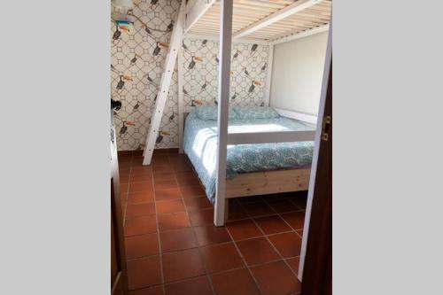 a small bedroom with a bunk bed and a tiled floor at Vuelos de Montaña l in Montánchez