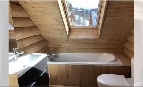 uma casa de banho com uma banheira, um WC e um lavatório. em Chalet Les Pins Blancs em Allos