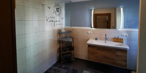 ein Bad mit einem Waschbecken und einem Spiegel in der Unterkunft Ferienwohnung Walter Gluche in Pittenhart