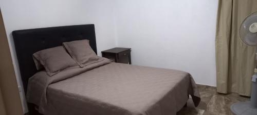 a bedroom with a bed with a black headboard at Cabañas de las Sierras in Tanti