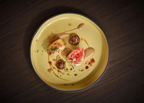 a yellow plate with food on a table at InterContinental Barcelona by IHG in Barcelona