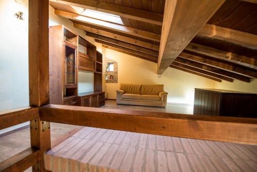 uma sala de estar com um sofá num quarto com tectos em madeira em Fattoria Branciana em Rossena