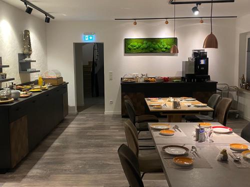 a restaurant with tables and chairs and a kitchen at Astrid's Pension in Winterberg