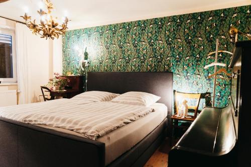 ein Schlafzimmer mit einem Bett und einer grünen Wand in der Unterkunft Tante Berg B&B in Bad Vilbel