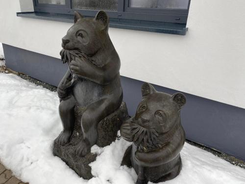 a statue of two bear statues in the snow at Astrid's Pension in Winterberg
