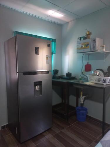 a kitchen with a stainless steel refrigerator and a desk at My little house in David