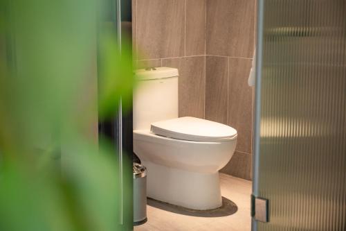 a bathroom with a white toilet in a room at 银座佳驿精致酒店（济阳汽车总站店） in Jiyang