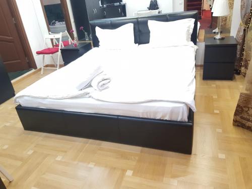 - un lit avec un cadre noir, des draps blancs et des oreillers dans l'établissement Spa Mega Mall Monza National Arena, à Bucarest
