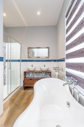 a white bathroom with two sinks and a tub at The Northwick Arms Hotel in Evesham