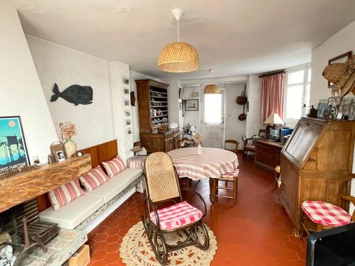 a living room with a table and a couch at Villa ROMEO , 250M de la plage in Saint-Georges-de-Didonne