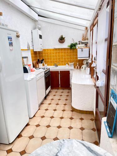 Il comprend une cuisine dotée d'appareils électroménagers blancs et de carrelage. dans l'établissement Villa ROMEO , 250M de la plage, à Saint-Georges-de-Didonne