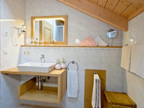 bagno con lavandino e specchio di Haus Wiesengrund a Frauenau