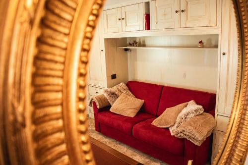 a red couch in a living room with a mirror at La Torre in Torrita di Siena