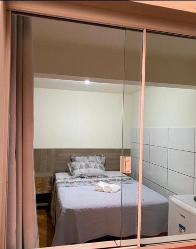1 dormitorio con 1 cama con pared de cristal en Hospedaria São José en Treze Tílias