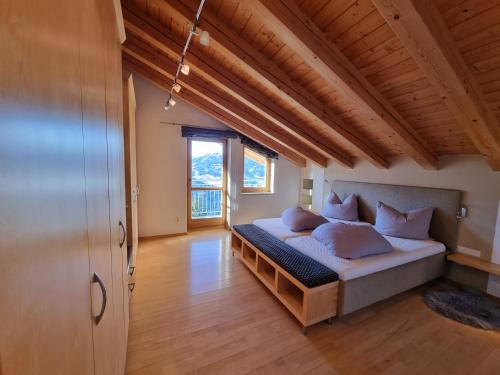 a bedroom with a bed in a room with wooden ceilings at Alpenapart Schultes Sports in Jerzens