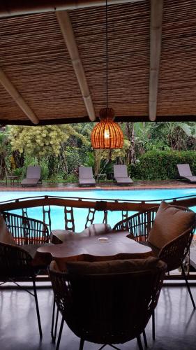 a table with chairs and a chandelier in a restaurant at Finca Luna Nueva Lodge in Fortuna