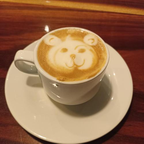 a cup of cappuccino with a monkey face on it at Finca Luna Nueva Lodge in Fortuna