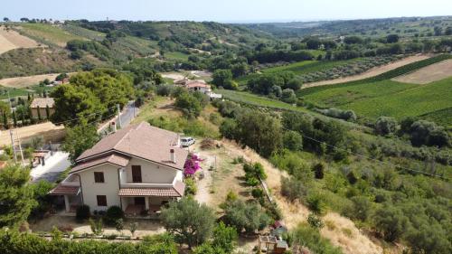 uma casa no topo de uma colina com campos verdes em Loft La Casa di Stefania em Pollutri