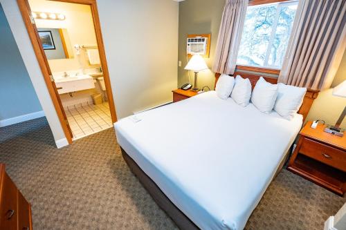 a hotel room with a large bed and a mirror at Blue Door Inn in Estes Park