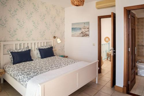 Un dormitorio con una cama blanca con almohadas azules. en CALERO DREAM by Buenavilla, en Puerto Calero