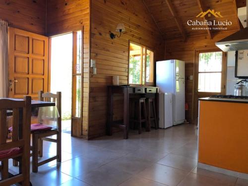 a kitchen with a refrigerator and a table in a room at Cabaña Lucio in Esquel