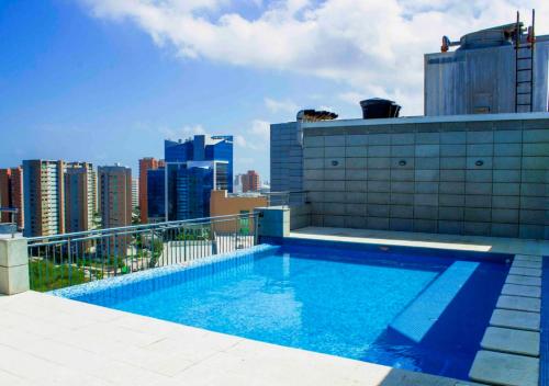 una piscina en la parte superior de un edificio con ciudad en Apartamento en Blue Gardens familiar Barranquilla, en Barranquilla