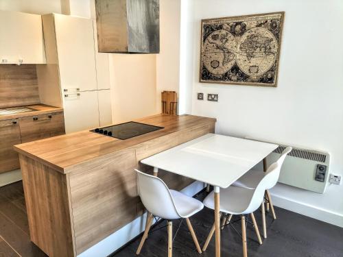 cocina con encimera de madera, mesa y sillas en Stylish & Cosy Abode with FREE parking. en Liverpool