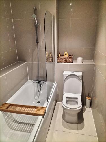 a bathroom with a toilet and a bath tub at Stylish & Cosy Abode with FREE parking. in Liverpool