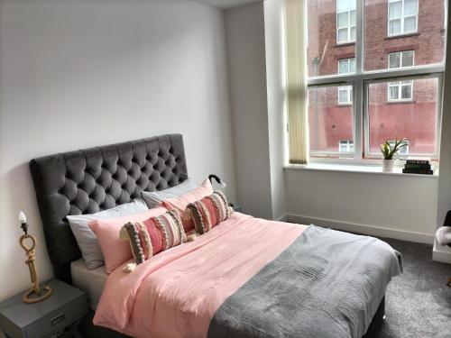Un dormitorio con una cama grande y una ventana en Stylish & Cosy Abode with FREE parking. en Liverpool