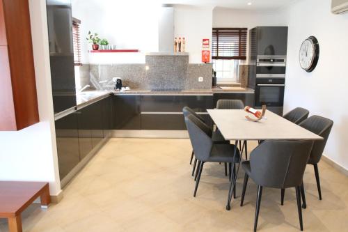 a kitchen and dining room with a table and chairs at Pine Tree Apartments - Praia da Coelha - Albufeira in Albufeira