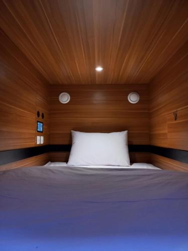 a bedroom with a bed with a wooden head board at Nindya Biodistrict Hotel Bandung in Bandung