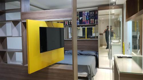 a bedroom with a bed with a yellow wall at Loft Lindo no Centro in Marabá