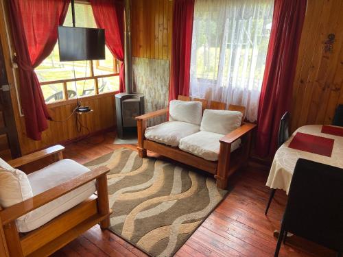 a living room with a couch and a window at Cabañas Campestres Villarrica in Villarrica