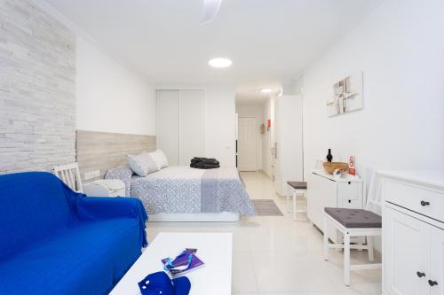 a white bedroom with a blue couch and a bed at Listen THE STARS 505 - Los cristianos in Los Cristianos