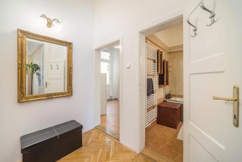 een hal met een spiegel aan de muur en een deur bij Vintage Apartment in Pécs