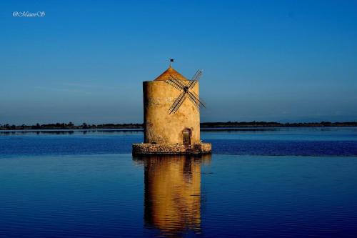 a windmill in the middle of a body of water at Il Belvedere - Cannelle beach Argentario - Tuscany in Monte Argentario