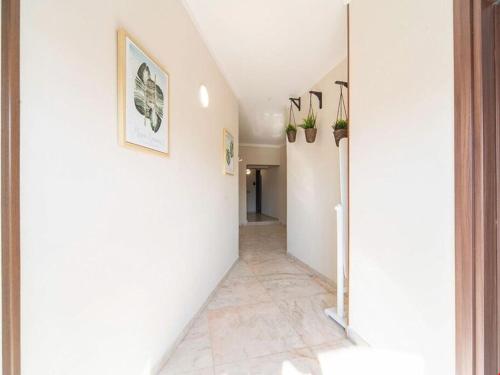um corredor com paredes brancas e piso em azulejo em POMPEI FELIX em Pompeia