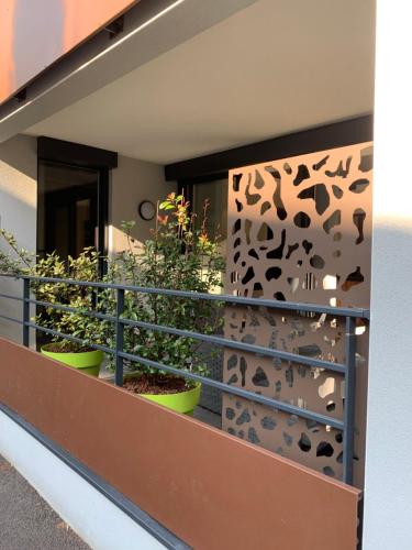 a balcony with plants in pots on a wall at Appartement le Saint Simond in Aix-les-Bains