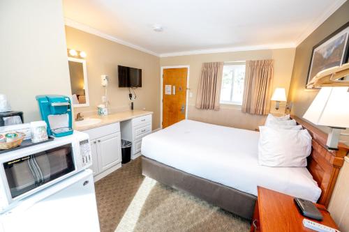 a hotel room with a large bed and a kitchen at Blue Door Inn in Estes Park
