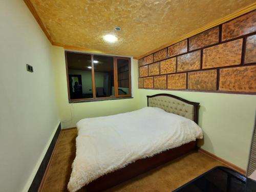 a bedroom with a bed and a brick wall at Phoenix Villa in Zarritʼapʼ