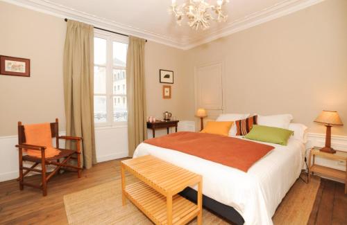 a bedroom with a large bed and a chandelier at Le Jardin Cathedrale in Chartres