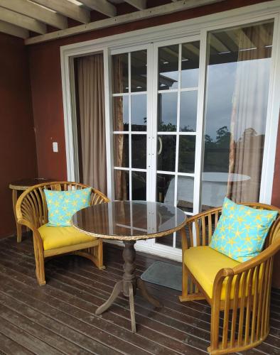 a glass table and two chairs on a porch at Condominio Hacienda Shangrila in San Francisco
