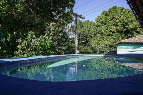 una piscina en un patio con árboles y una casa en Pousada Coração do Arraial, en Arraial d'Ajuda