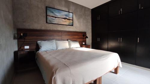 Schlafzimmer mit einem großen Bett mit einem Kopfteil aus Holz in der Unterkunft New House with Private Pool in Manzanillo