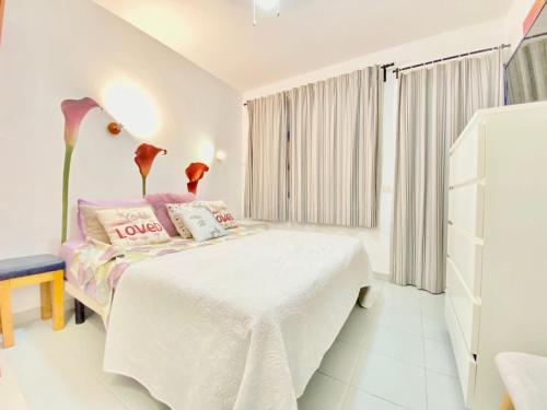 a white bedroom with a bed and a window at Bungalow Playmar in Playa del Ingles