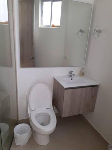 a bathroom with a toilet and a sink and a mirror at Villa Juliana in Carmen de Apicalá