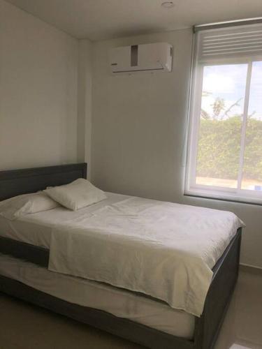 a bedroom with a large bed with a window at Villa Juliana in Carmen de Apicalá