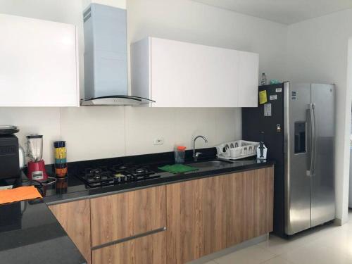 a kitchen with a stove and a refrigerator at Villa Juliana in Carmen de Apicalá