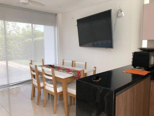 a kitchen with a table with chairs and a television at Villa Juliana in Carmen de Apicalá